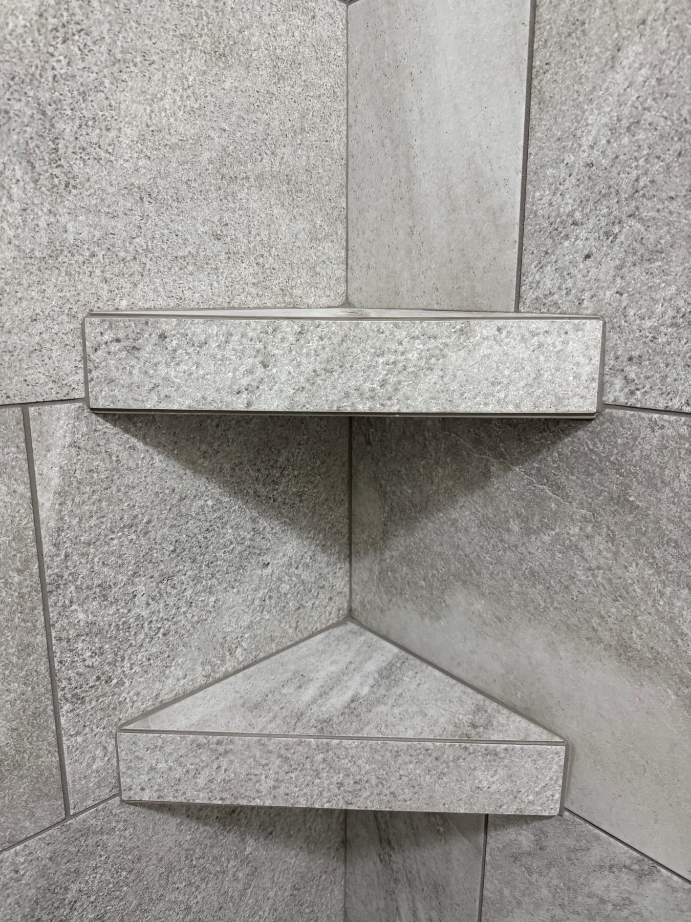 Marble tile shower with built-in corner shelves