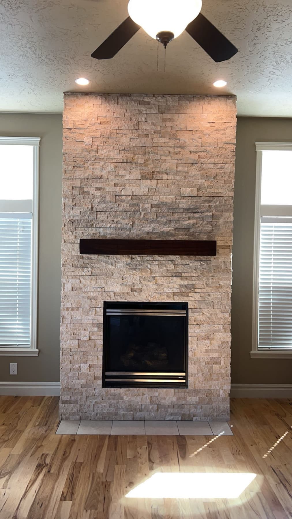 Brick-look tile fireplace with wood mantel