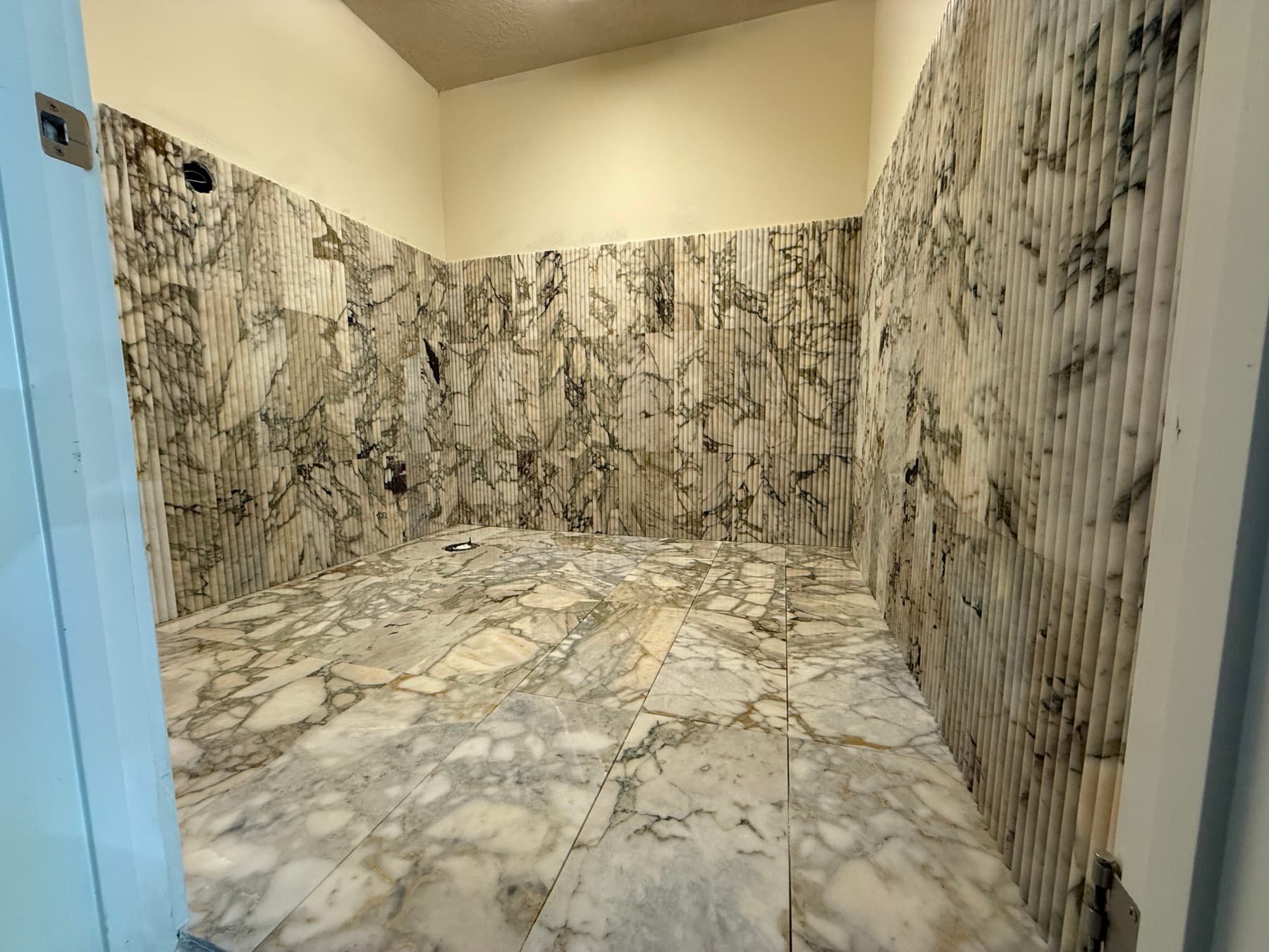 Large-format marble shower tile in a new construction master bath