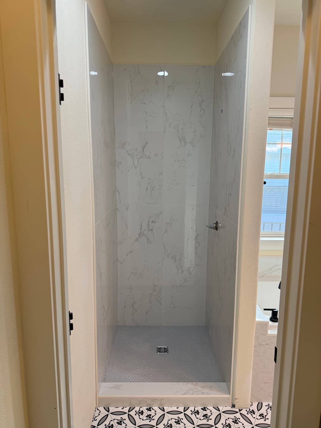 Marble tile shower with a decorative patterned border